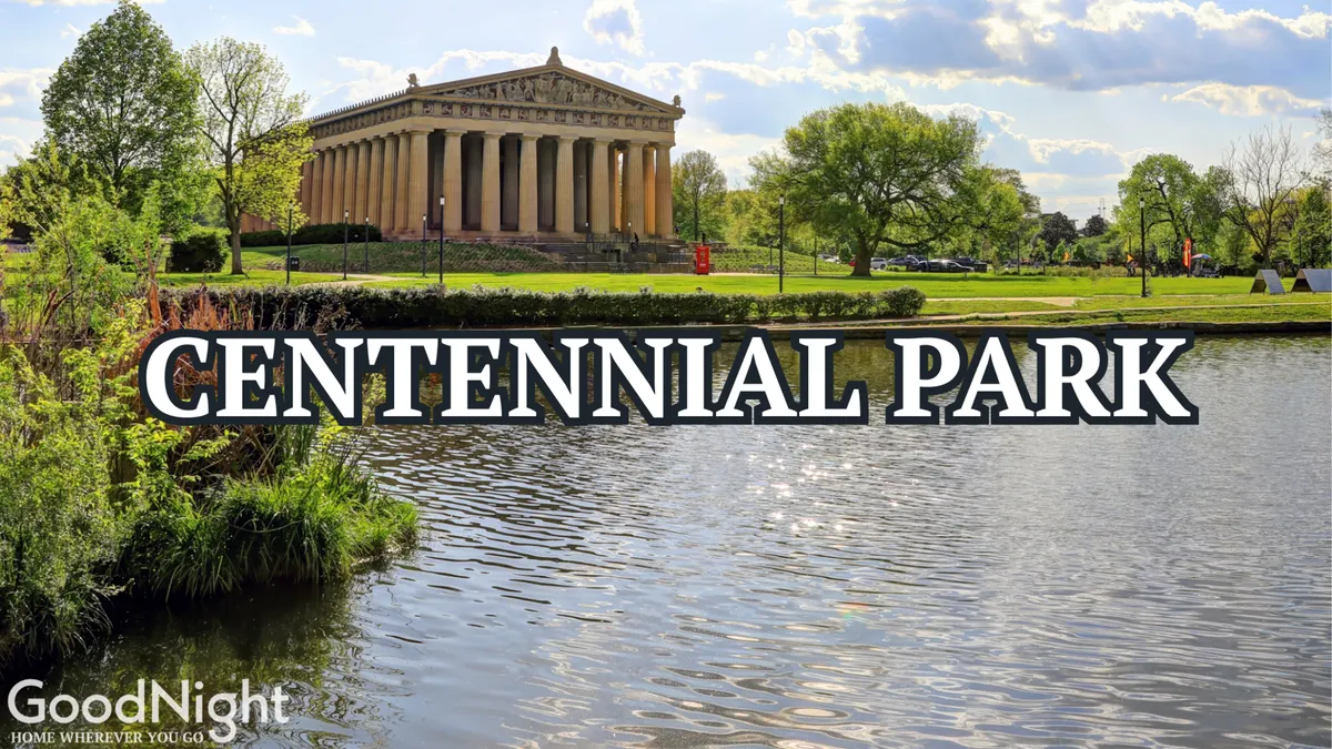 A majestic Parthenon-like structure is set beside a reflective body of water, framed by lush green lawns and mature trees. The scene is lively yet serene, ideal for outdoor activities like picnicking, walking, or attending community events. The Parthenon is a major landmark within Centennial Park, one of the family-friendly attractions mentioned.